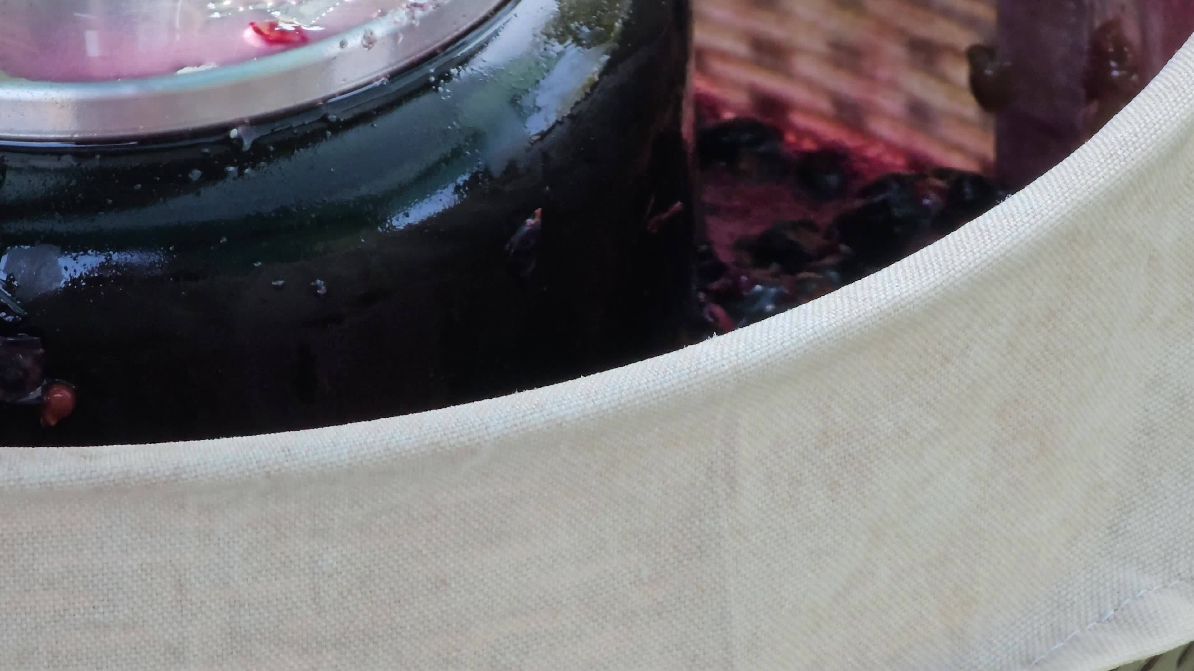 The process of making homemade grape wine. Grapes are pressed in a