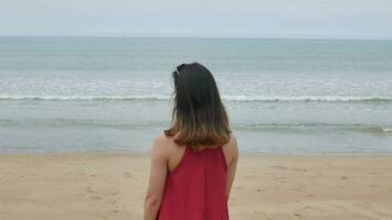 een jong Aziatisch vrouw wandelen Aan de strand en kom tot rust terwijl Aan vakantie vakantie video