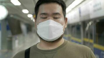 homem sorrisos vestindo mascarar enquanto esperando para metrô público transporte trai video