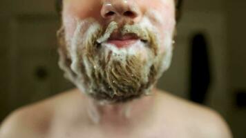 Man with Shampoo filled beard blows bubbles away from mouth video