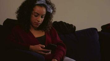 Latino Woman Upset on the Couch, Concerned Looking at her Phone in Slow Motion video