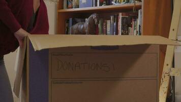 joven Hispano mujer embalaje arriba donación caja para caridad video