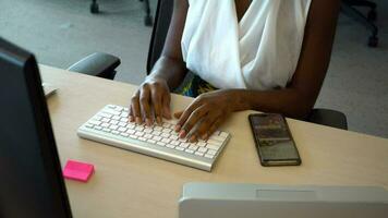 Young diverse businesswoman typing on computer keyboard, working hard video