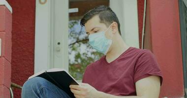 4k Kaukasisch Mens met masker journaling Bij huis gedurende pandemisch video
