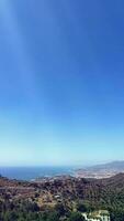 Vertical Video of coastline of Malaga city, view from above with clear blue sky. Spain.