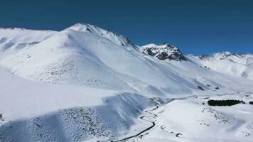 aéreo ver zumbido volador terminado hermosa blanco Nevado montañas video