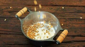 raw popcorn kernels falling into the pan video