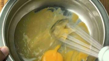 Eggs in stainless steel bowl being beaten for omelet video
