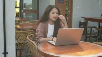 A portrait of Asian business woman looks stressed and depressed while working from coffeeshop video