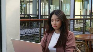 A portrait of Asian business woman looks stressed and depressed while working from coffeeshop video