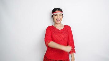 A young Asian woman with a happy successful expression wearing red kebaya and headband isolated by white background. Indonesia's independence day concept. video