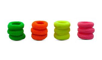 Pile of green orange yellow and pink hair ties scrunchies isolated on white background photo