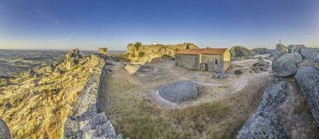 panorámico imagen de el fortificación encima el histórico pueblo de Monsanto en Portugal durante amanecer foto