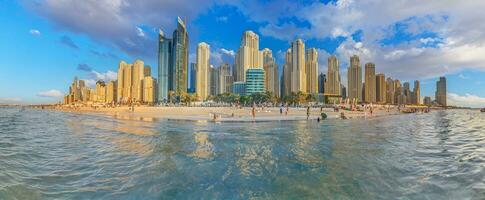 Panoramic view over beach and skyline of Marina district in Dubai during sunset photo