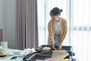 Woman packing suitcase on bed for a new journey packing list for travel planning preparing vacation Book Now Traveling Transportation photo