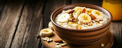 Wholesome oatmeal breakfast with banana slices honey and nuts on wood photo