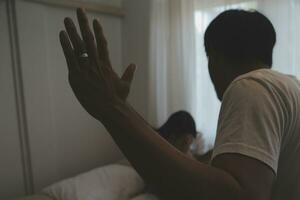 Upset woman having a fight with a man at home. Hispanic wife slapping the face of her husband during an argument because of their relationship problems photo