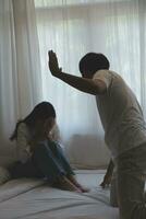 Upset woman having a fight with a man at home. Hispanic wife slapping the face of her husband during an argument because of their relationship problems photo