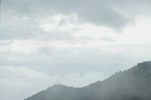 Mountain range with visible silhouettes through the morning blue fog. photo