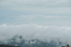 Mountain range with visible silhouettes through the morning blue fog. photo