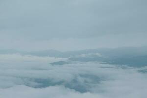 Mountain range with visible silhouettes through the morning blue fog. photo