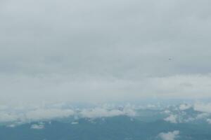 Beautiful panoramic view of fog and clouds in distant layers mountains range with blue sky in morning photo