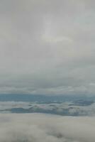 Mountain range with visible silhouettes through the morning blue fog. photo