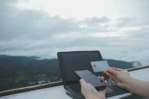 online payment, young woman holding credit card and typing on laptop photo