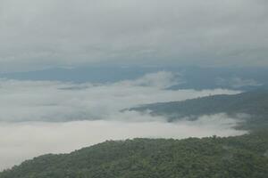 Mountain range with visible silhouettes through the morning blue fog. photo