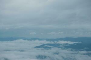 Mountain range with visible silhouettes through the morning blue fog. photo