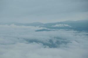 Mountain range with visible silhouettes through the morning blue fog. photo