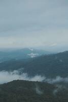 Mountain range with visible silhouettes through the morning blue fog. photo