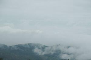 Mountain range with visible silhouettes through the morning blue fog. photo