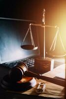 law legal technology concept. judge gavel on computer with scales of justice on desk of lawyer. photo