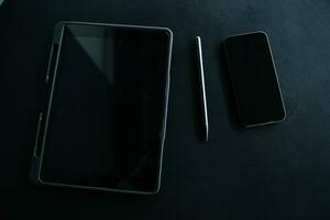 Open laptop with digital tablet and white smartphone. All with isolated screen on old wooden desk. photo