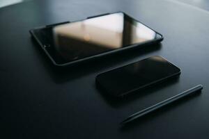 Open laptop with digital tablet and white smartphone. All with isolated screen on old wooden desk. photo