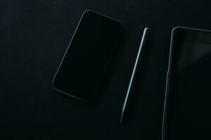 Open laptop with digital tablet and white smartphone. All with isolated screen on old wooden desk. photo