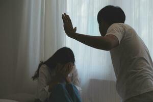 Upset woman having a fight with a man at home. Hispanic wife slapping the face of her husband during an argument because of their relationship problems photo