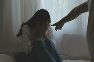 Upset woman having a fight with a man at home. Hispanic wife slapping the face of her husband during an argument because of their relationship problems photo