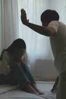 Upset woman having a fight with a man at home. Hispanic wife slapping the face of her husband during an argument because of their relationship problems photo