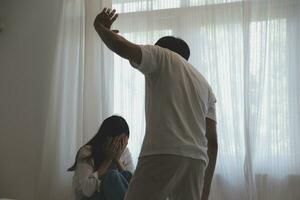 Upset woman having a fight with a man at home. Hispanic wife slapping the face of her husband during an argument because of their relationship problems photo