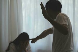 Upset woman having a fight with a man at home. Hispanic wife slapping the face of her husband during an argument because of their relationship problems photo