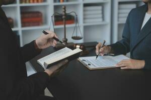 Business and lawyers discussing contract papers with brass scale on desk in office. Law, legal services, advice, justice and law concept picture with film grain effect photo