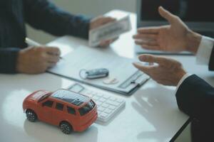 Closeup asian male people car salesman or sales manager offers to sell a car and explains and reads the terms of signing a car contract and insurance. photo