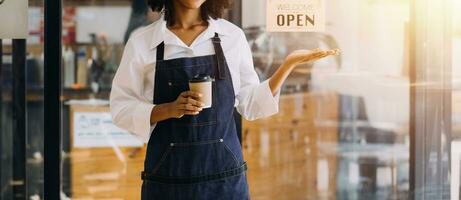 Startup successful small business owner sme beauty girl stand with tablet smartphone in coffee shop restaurant. Portrait of asian tan woman barista cafe owner. SME entrepreneur seller business concept photo