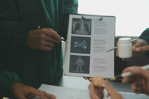 Multiracial team of doctors discussing a patient standing grouped in the foyer looking at a tablet computer, close up view photo