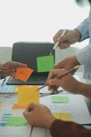 Close up ux developer and ui designer brainstorming about mobile app interface wireframe design on table with customer breif and color code at modern office.Creative digital development agency photo