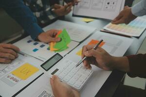 Close up ux developer and ui designer brainstorming about mobile app interface wireframe design on table with customer breif and color code at modern office.Creative digital development agency photo