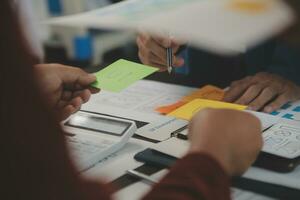 Close up ux developer and ui designer brainstorming about mobile app interface wireframe design on table with customer breif and color code at modern office.Creative digital development agency photo