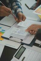 Close up ux developer and ui designer brainstorming about mobile app interface wireframe design on table with customer breif and color code at modern office.Creative digital development agency photo